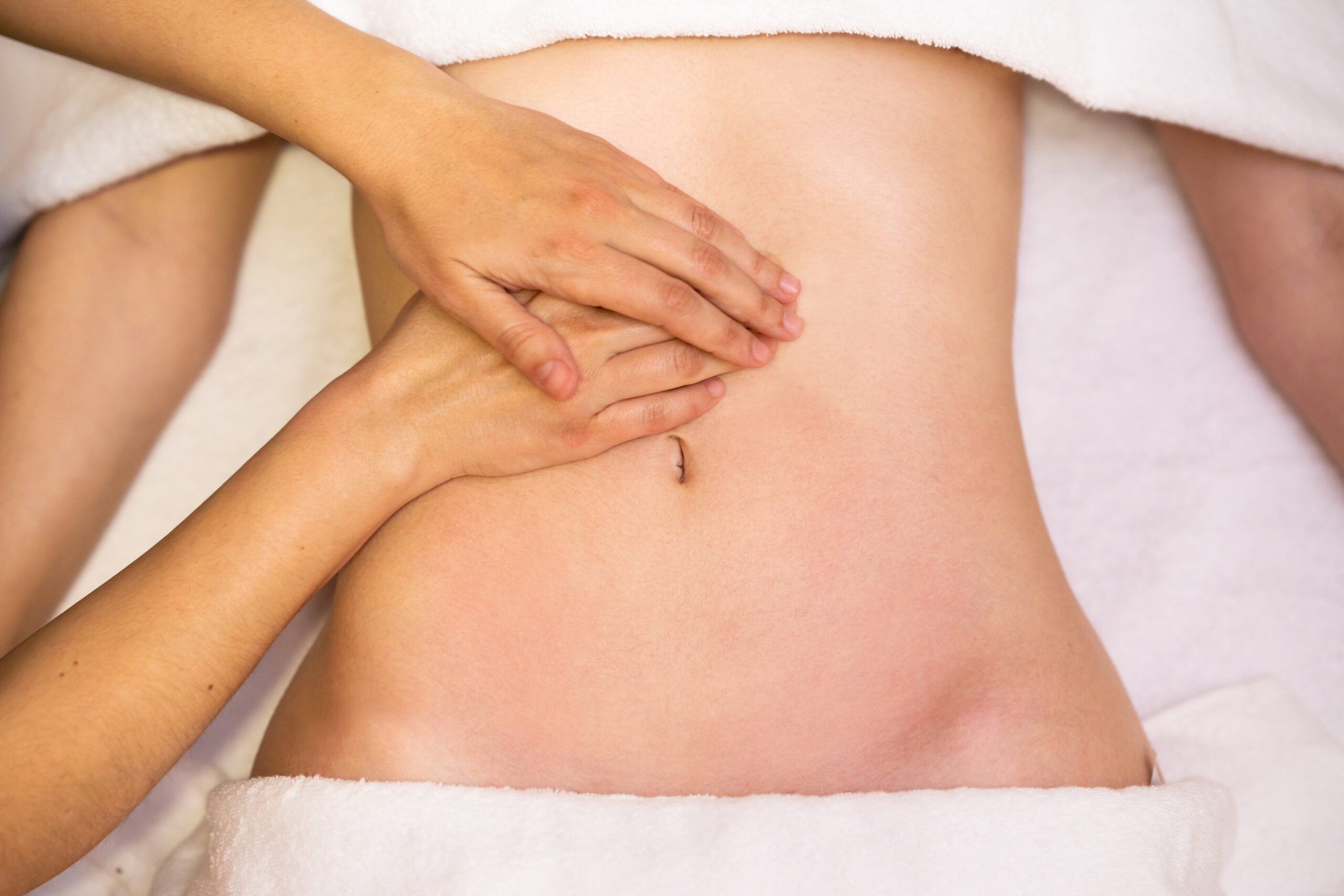 Woman receiving a belly massage at spa salon